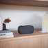 Schwarzer Go 300 Care Lautsprecher auf einem Holzregal neben Büchern | Go 300 Care | sackit