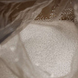 Weiße EPS-Kugeln als Nachfüllpackung für Sitzsäcke, 100 Liter Inhalt in transparenter Verpackung.