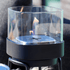 Schwarze SACKit Bio Lamp Ø14 aus Edelstahl mit Glas, auf Holztisch im Außenbereich. | Bio Lamp - Ø14 - | SACKit