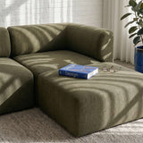 Olivgrünes Fjord Sofa mit großzügigem Pouf in hellem skandinavischem Wohnzimmer mit Buch und Brille auf dem Polster | Fjord Sofa - Pouf - Cosmo Mustard | SACKit