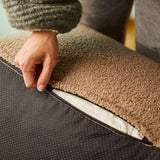 Detailaufnahme des Soft Sofa Indoor mit geöffneter Polsterhülle und sichtbarem Reißverschluss unter dem weichen Bouclé Bezug in warmem Braun