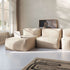 Beiges modulares Sofa von sackit mit drei Sitzelementen und Lounger in einem hellen Wohnzimmer mit Kunstwerk und gemustertem Teppich