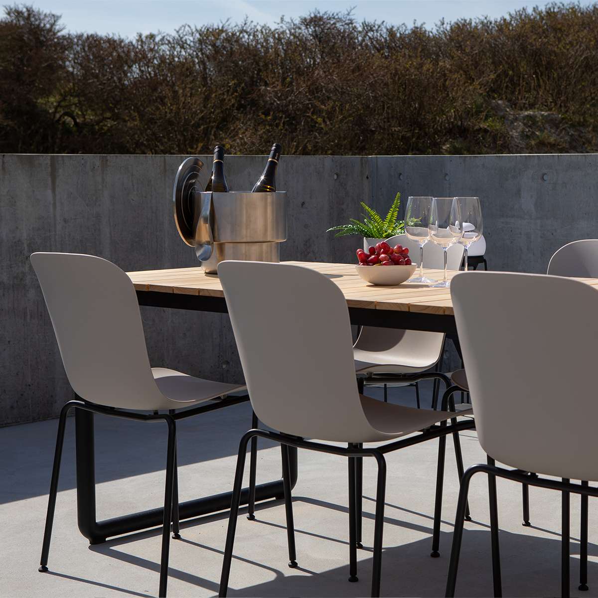 Patio Chair no. One S1 mit taupefarbener Sitzschale und schwarzem pulverbeschichtetem Stahlgestell draußen auf Terrasse | Patio Chair no. One S1 - Olive/Black | SACKit