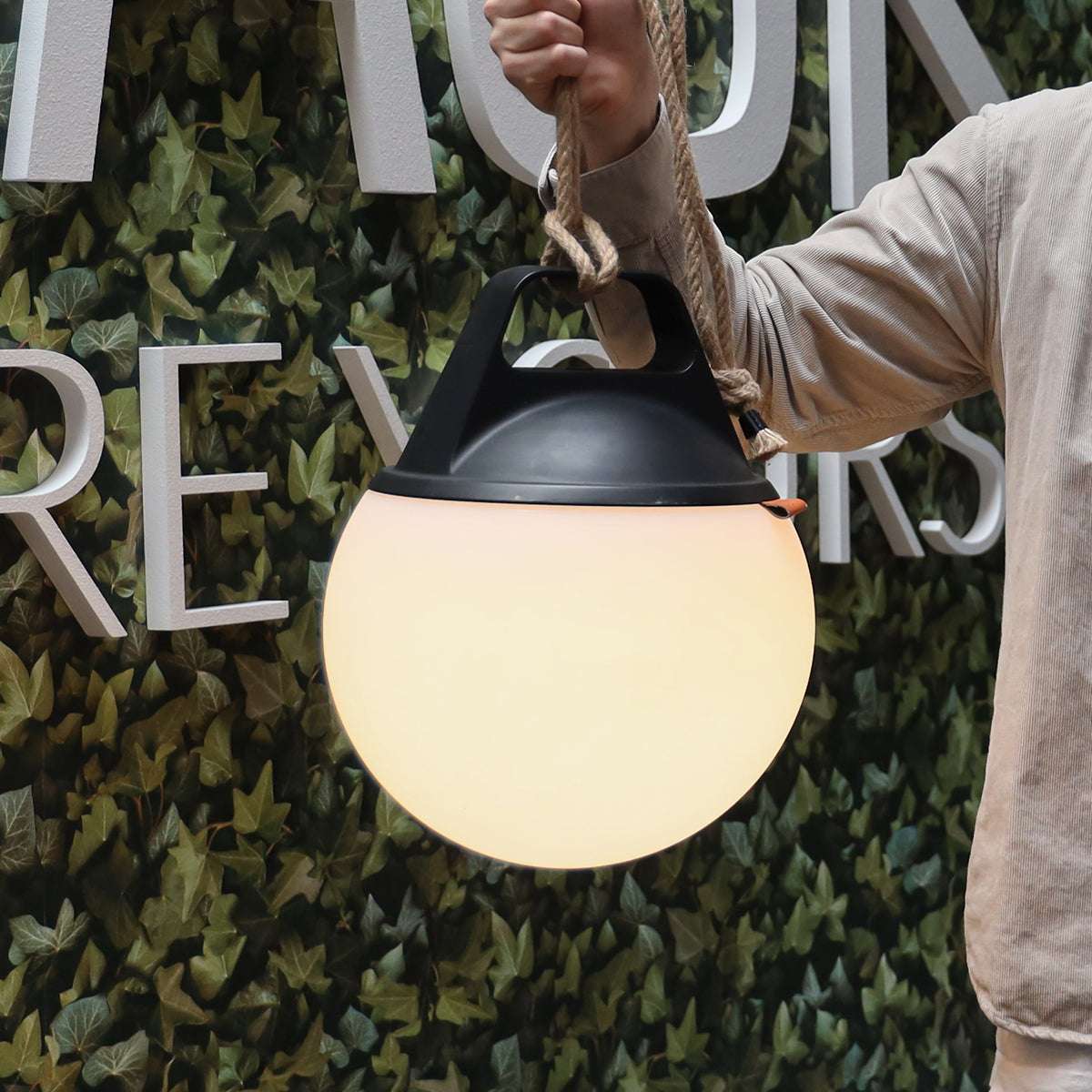 Zwei runde SACKit Light 250 Outdoor-Lampen mit Hanfseilgriff und weißem Lampenkörper.