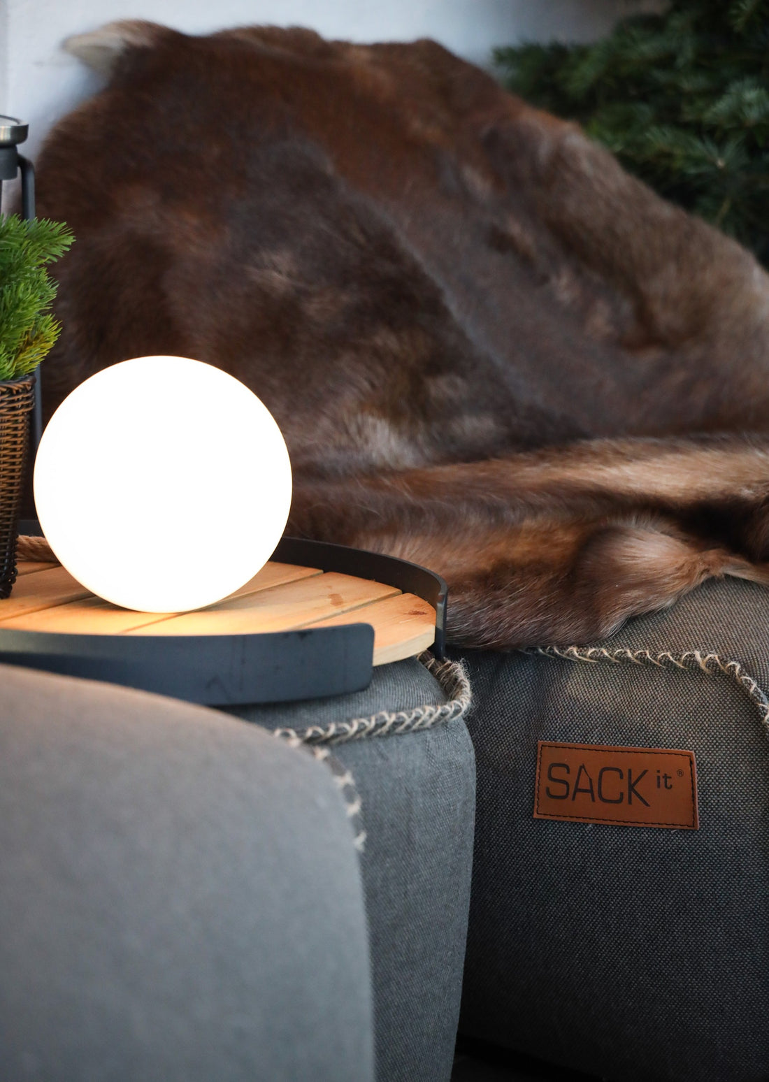 Nahaufnahme von strapazierfähigen SACKit-Sitzsäcken, Außenlampen und Serviertabletts im Café Peace