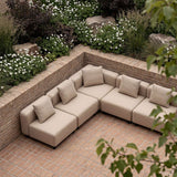 Beiges modulares Outdoor Ecksofa mit fünf Sitzplätzen und Kissen auf einer gemauerten Terrasse im blühenden Garten von sackit | Cobana Lounge Sofa - 5 seater corner sofa - Kirra Sand Ohne Armlehnen | SACKit