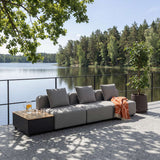 Graues modulares Outdoor Sofa auf einer Terrasse am See mit schwarzem Beistelltisch orangefarbener Decke und skandinavischem Design von sackit | Cobana Lounge Sofa - Seat - Kirra Indigo | SACKit
