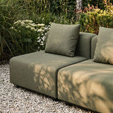 Grünes modulares Outdoor Sofa mit zwei Sitzplätzen und Kissen auf hellem Kies in einem üppigen Garten gestaltet in Dänemark für nordisches Wetter | Cobana Lounge Sofa - 4 seater corner sofa - Kirra Sand Mit Armlehnen | SACKit