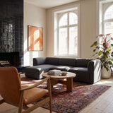 Skandinavisches Wohnzimmer mit dunkelgrauem Fjord Sofa und linker Chaiselongue von sackit vor großen Fenstern mit Teppich Couchtisch und Zimmerpflanze | Fjord Sofa - Chaise Left - Cosmo Clay | SACKit