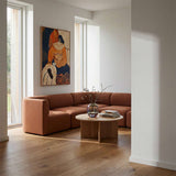 Braunes Fjord Ecksofa von sackit in einem hellen skandinavischen Wohnzimmer mit Holzboden rundem Couchtisch und abstrakter Wandkunst | Fjord Sofa - Corner Sofa - Cosmo Terracotta | SACKit