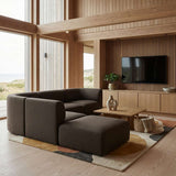 Dunkles skandinavisches Sofa mit passendem Pouf in einem hellen Wohnzimmer mit Holzbalken großen Fenstern und modernem Medienmöbel von sackit | Fjord Sofa - Corner Sofa w/ open end - Cosmo Terracotta | SACKit