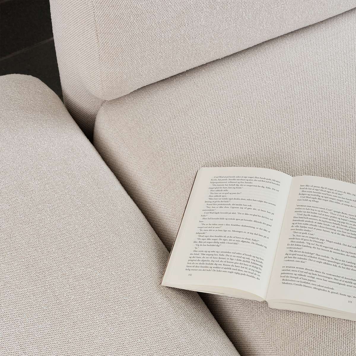 Nahaufnahme des beigefarbenen Fjord Ecksofas von sackit mit offenem Ende und einem aufgeschlagenen Buch auf der weichen Polsterung | Fjord Sofa - Corner Sofa w/ open end - Cosmo Terracotta | SACKit