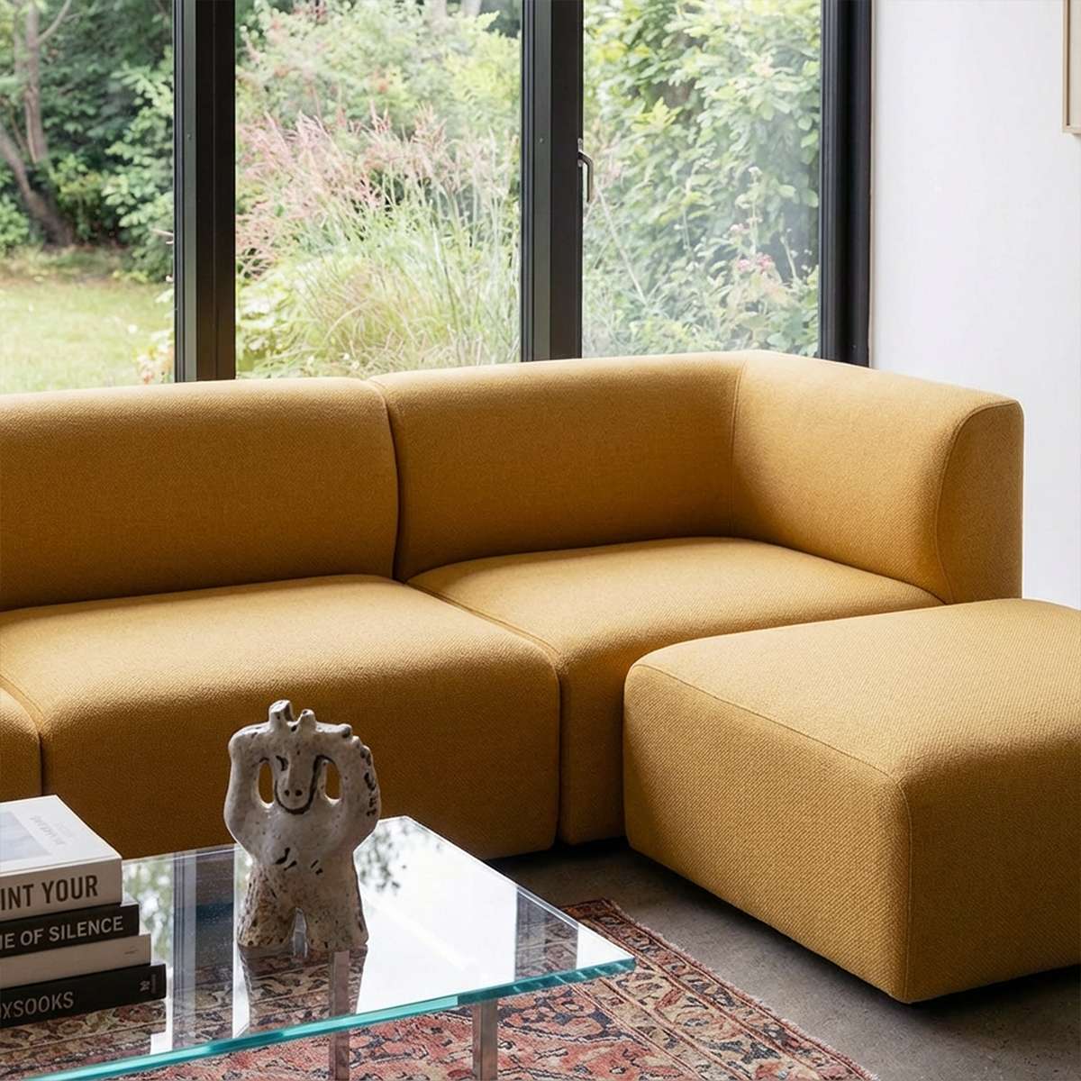 Senfgelbes skandinavisches Sofa mit passendem Pouf im hellen Wohnzimmer vor großen Fenstern mit Blick in den Garten von sackit | Fjord Sofa - Pouf - Cosmo Mustard | SACKit