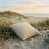 Beiges quadratisches Outdoor-Kissen liegt im Sand der Dünen | Outdoor Cushion Square | sackit