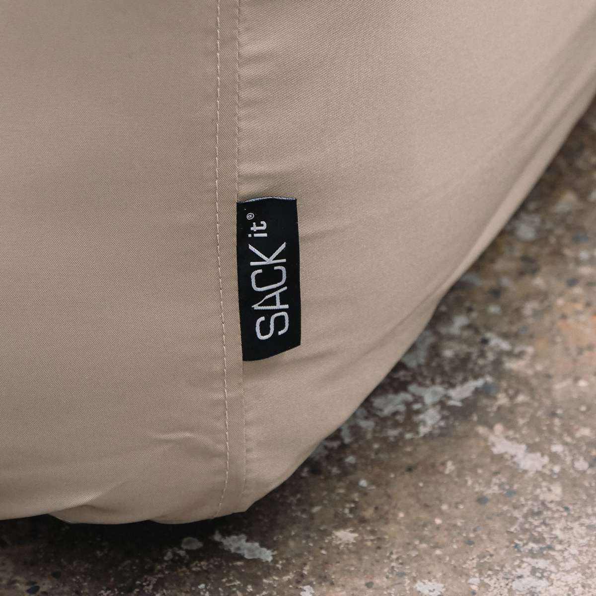 Detailaufnahme der wasserabweisenden Schutzhülle für das Soft Sofa mit sichtbarem sackit Markenlabel und robusten Nähten für den Außenbereich