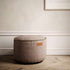 Brauner Canvas Pouf von sackit als runder Sitzhocker mit dekorativer Kedernaht in einem stilvollen Innenraum auf Holzboden | Canvas Pouf - Canvas Petrol | SACKit