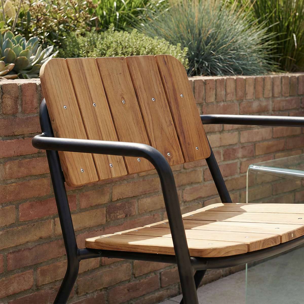 Kirra Patio Lounge Chair in Noir mit pulverbeschichtetem Aluminium und Teakholz, entspannte Sitzposition draußen | Kirra Patio Lounge Chair - Noir | SACKit